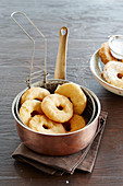 Apple beignets in a frying basket