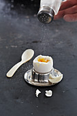 Salt being sprinkled onto a boiled eggs