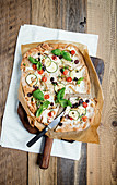 Mediterranean tarte flambée with cream cheese, courgettes and olives