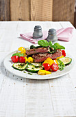 Seared beef steaks with colourful fried vegetables