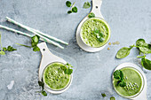 Three green smoothies with bok choy, melon, spinach, lamb's lettuce and kiwi