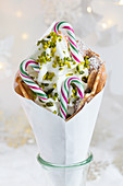 A bubble waffle with frozen yogurt, pistachios and striped candy canes for Christmas