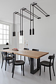 Pairs of pendant lamps above dining table in white room
