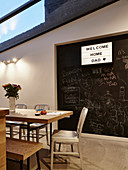 Illuminated panel on chalkboard wall in dining room with glass room