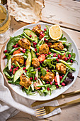 Vegetable salad with curry chicken and pomegranate seeds (India)