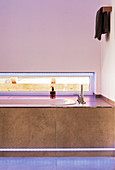 Bathtub with strip lighting below narrow horizontal window