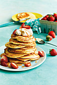 Pancakes mit Frischkäsefüllung und Erdbeersauce, gestapelt auf Teller