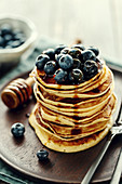 A stack of pancakes with blueberries and maple syrup