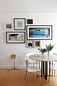 Round table, chairs and framed photos on wall in dining area