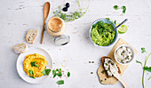 A pepper and sheep's cheese dip, a carrot dip, guacamole and a smoked fish dip