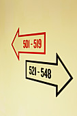Arrows pointing to room numbers in hotel hallway