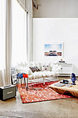 White cushion sofa on reddish carpet in front of window and wooden coffee table