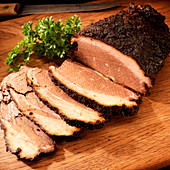Sliced smoked beef brisket on cutting board