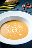 Sweet peanut cream soup garnished with double cream in a white plate