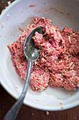 Meatballs being made: minced meat and ingredients being mixed
