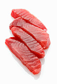 Four fresh tuna fish steaks on a white surface