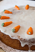 Carrot cake decorated with icing and marzipan carrots