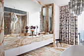 Bathroom with marble vanity, marble tiled floor and Murano glass chandelier above the bathtub