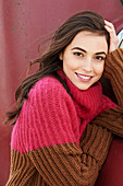 A young brunette woman wearing a bi-coloured knitted jumper