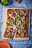 Pizza with duck confit, red onions and rocket