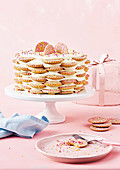 Fairy bread cake with cream cheese buttercream and biscuits on a cake stand