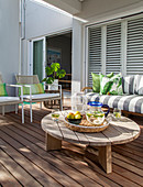 Round coffee table and sofa on terrace with wooden flooring