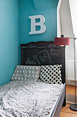 Buchstabe überm mit Tafellack gestrichenen Kinderbett
