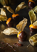Physalis with chocolate icing on a metal surface