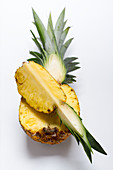 A half and a quarter slice of pinapple against a white background