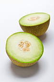 A halved honeydew melon against a white background