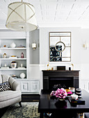 Bright living room with dark coffee table, fireplace and shelf