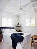 Double bed and ceiling fan in the bedroom with white wooden roof structure