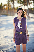 A young brunette woman wearing a purple mini dress