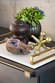 Decorative arrangement of stone encrusted with crystals, sculptures and vase on tray