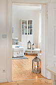Blick ins Wohnzimmer mit hellem Holzdielenboden und weißen Möbeln in umgebauter Molkerei