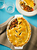 Beef and Guinness pie with a serving on a plate