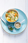 Möhren-Zucchini-Suppe mit Mais und Käse-Flocken-Topping