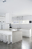 weiße Küche mit Kochinsel und Arbeitsplatten aus Beton
