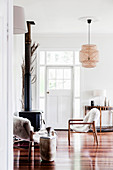 Two chairs with animal fur in front of a fireplace in a white living room