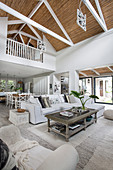 Coffee table and white sofa in open-plan double-height interior