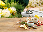 Grilling utensils, sauces and spices on garden table
