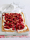 A raspberry tart with cream, sliced