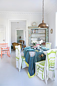 Set table in white dining room with brightly coloured accents