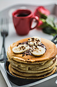 Ein Stapel Pancakes mit Bananen und Schokolade