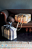 Selbstgenähte Stofftaschen mit Karomuster auf einem alten Sofa