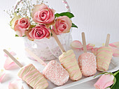 Cheesecakes on sticks with white and pink chocolate icing