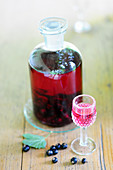 Home-made blackcurrant liqueur in glass and bottle