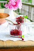 Wild strawberry jam in a glass jar on a summer garden table