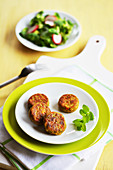 Small vegetable patties with a plate of salad