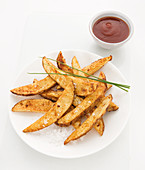 Potato wedges backed with paprika, sprinkled with sea salt and chives, Tomato sauce on side